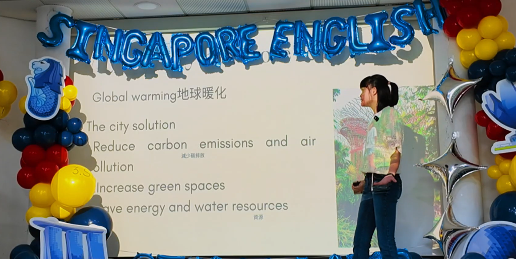 スクリーンの前で英語プレゼンをする参加者